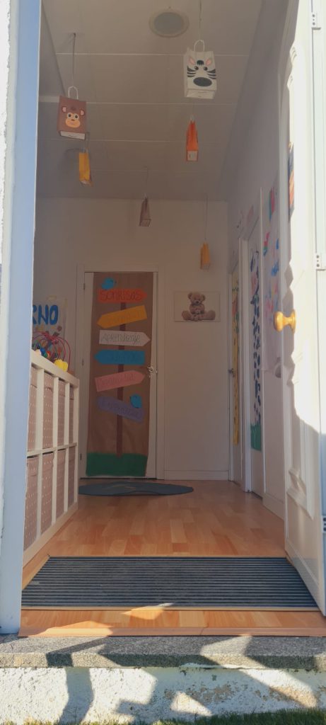 Pasillo de entrada desde el exterior. Las puertas y paredes tienen cartulinas de colores.