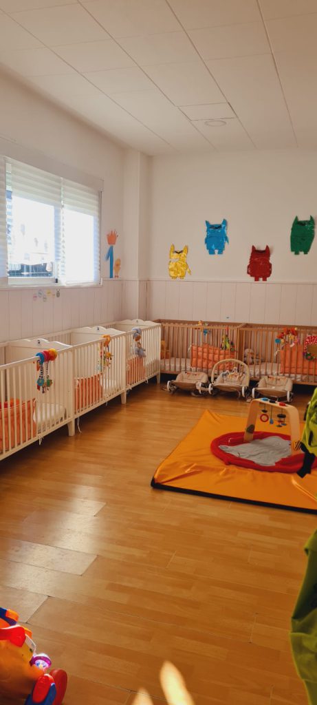 Sala con cunas, gimnasio para bebé y juguetes